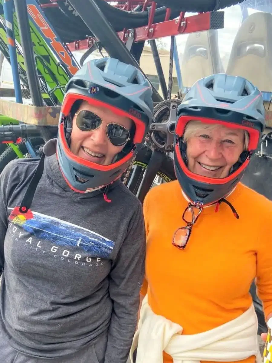 Bicycling Pikes Peak. Two women are ready to ride down the mountain in their heavy-duty helmets.