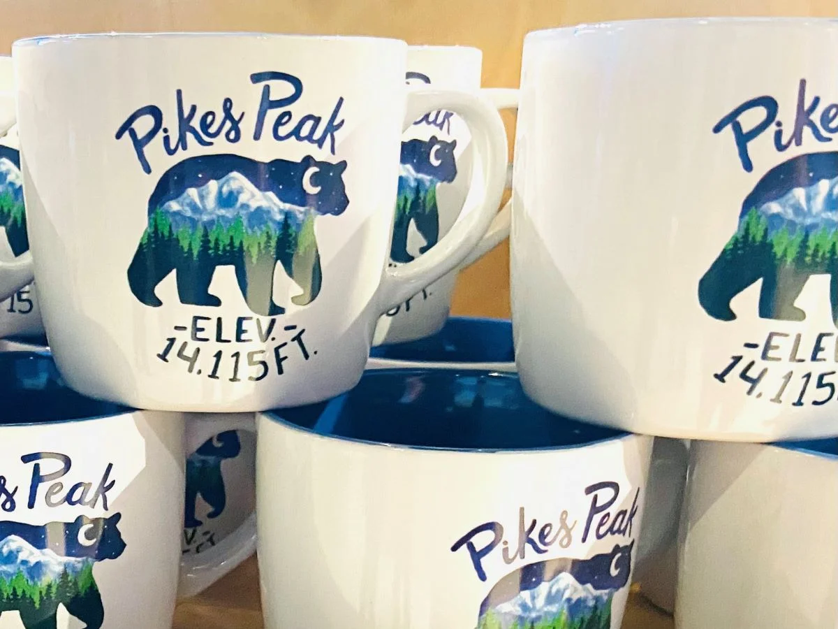 Coffee cups with Pikes Peak elevation listed for sale at the Visitors Center before bicycling Pikes Peak.