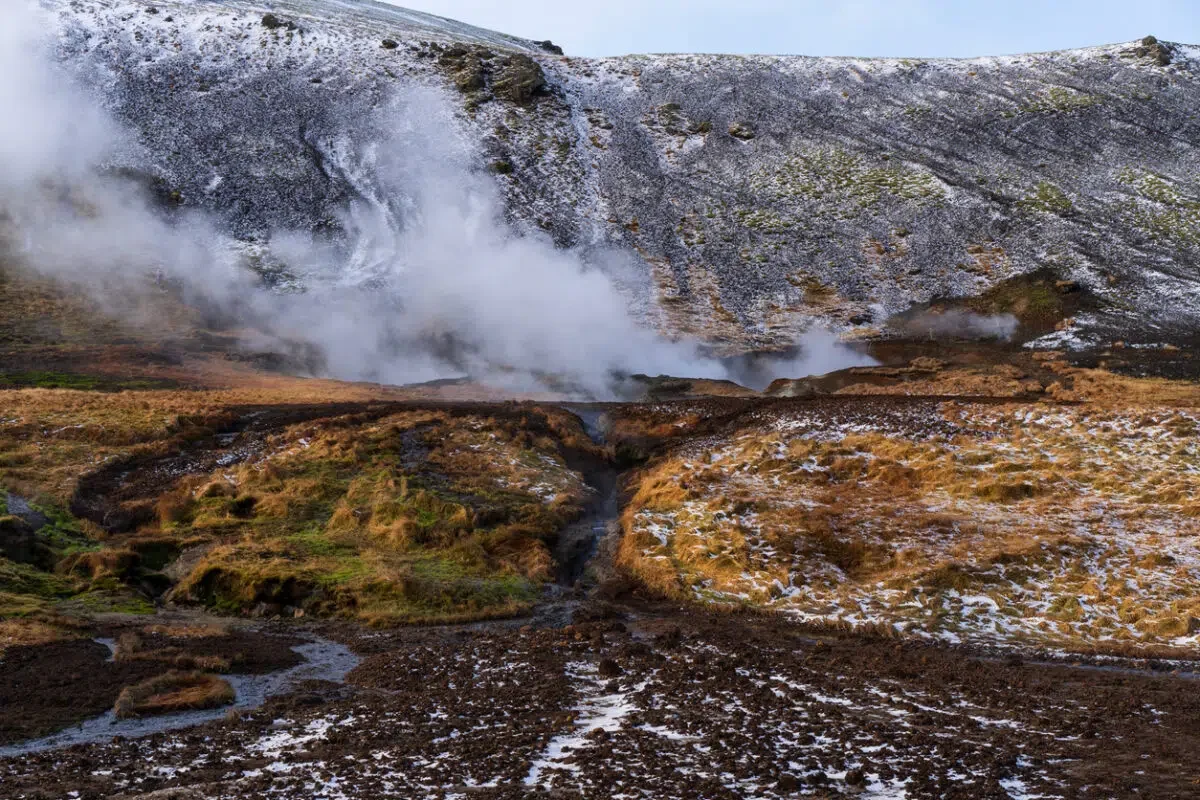 Panoramic view of the Reykjadalur hot springs hiking trail at sunset, with a hot river flowing through a picturesque valley. One of the best hikes in Iceland