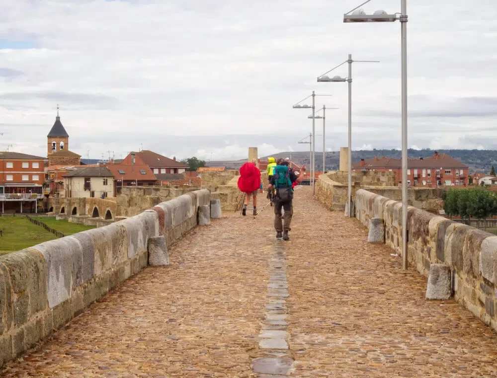 Hospital de Orbigo, Castile and Leon, Spain - September 23, 2014: Pilgrims walk on the 13th century Medieval bridge over the Orbigo River