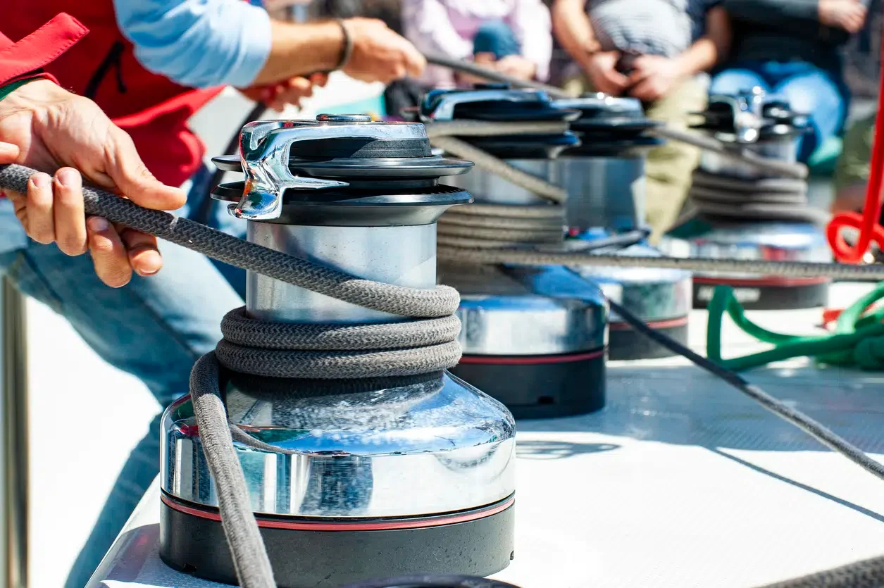 Sailors using powered winches to pull lines